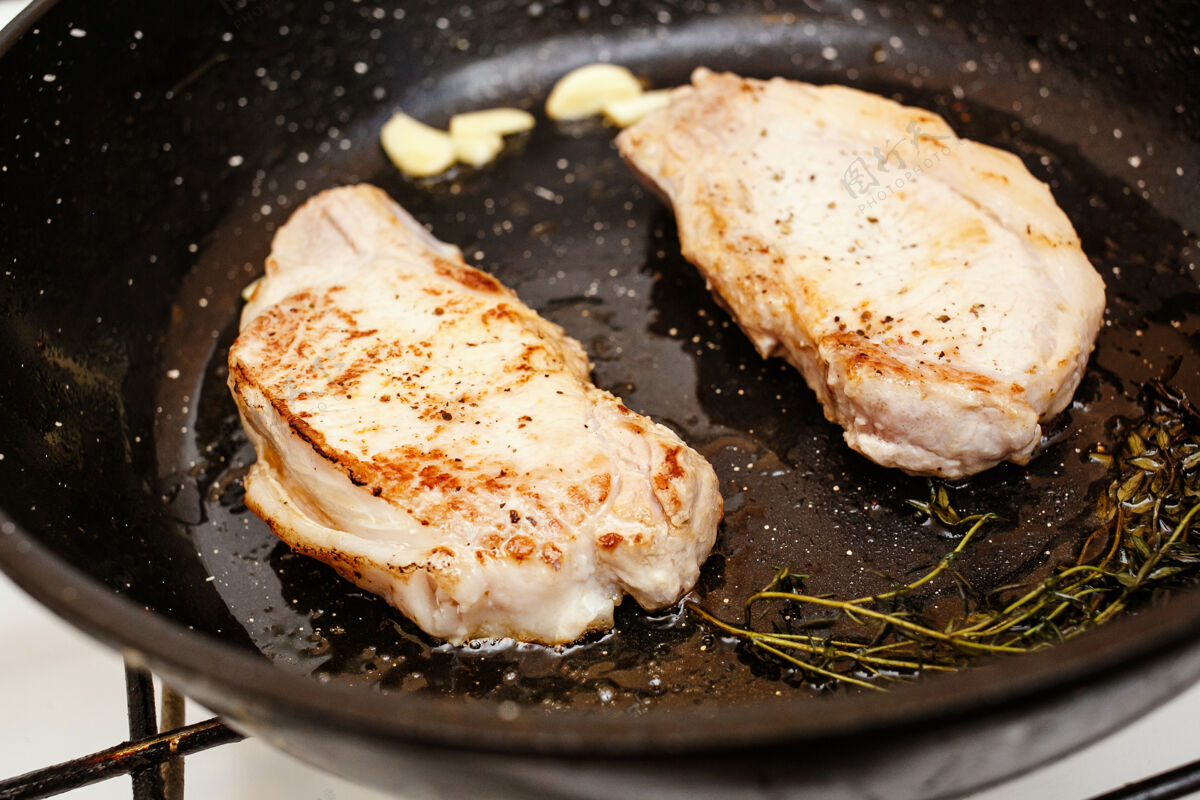 餐桌多汁的肉排在锅里 烹饪食物的顶端膳食脂肪热