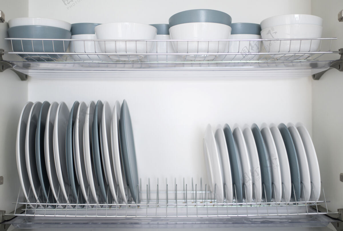餐具盘子和碗堆在厨房的烘干机上设置洗厨房用具