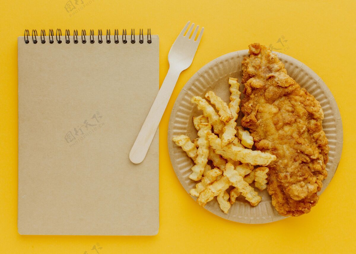 餐带叉子和笔记本的盘子上的鱼和薯条的俯视图英语美食菜