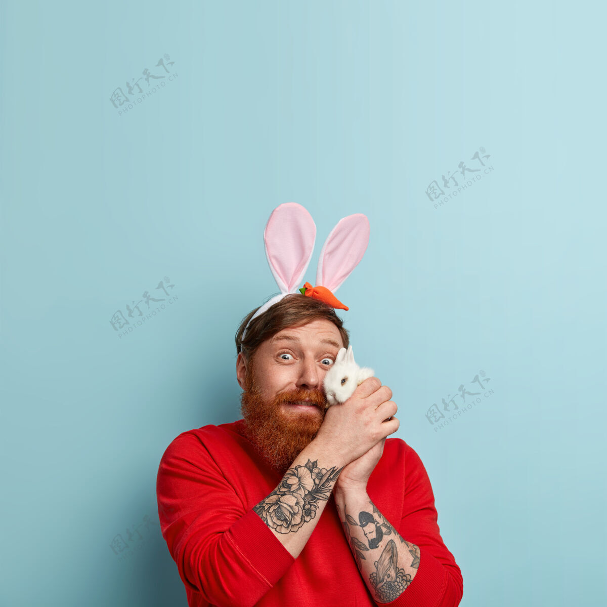 摆姿势姜黄胡子的男人穿着五颜六色的衣服和兔子耳朵人人兔子