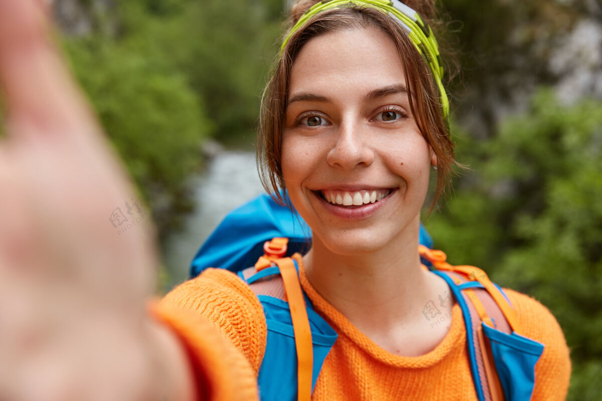 业余时间旅游女远足者自拍肖像 对着镜头微笑乐观背包高兴