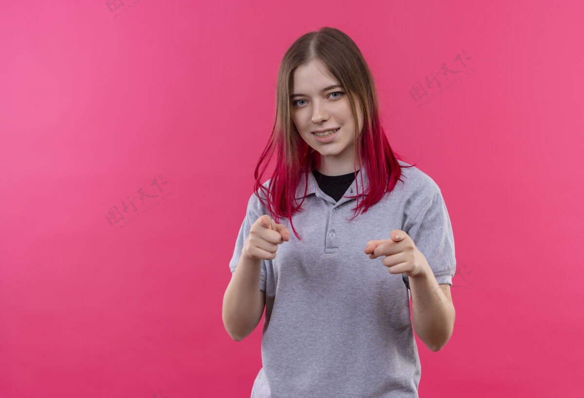 粉色微笑的年轻漂亮女孩穿着灰色t恤 在孤立的粉色背景上展示你的手势女孩T恤穿着