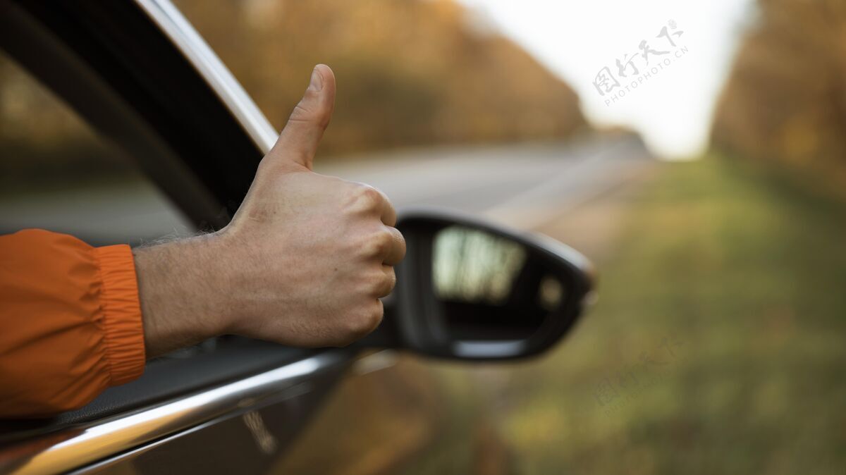 探险一个在公路旅行时从车里竖起大拇指的男人旅行复制竖起大拇指