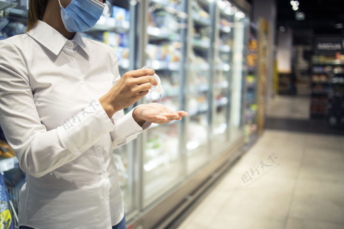 口罩在超级市场购物时手部消毒以防电晕病毒预防购物摩擦