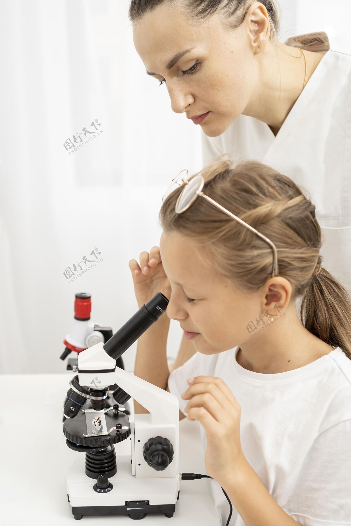 女孩和女老师一起学看显微镜的女孩孩子科学知识
