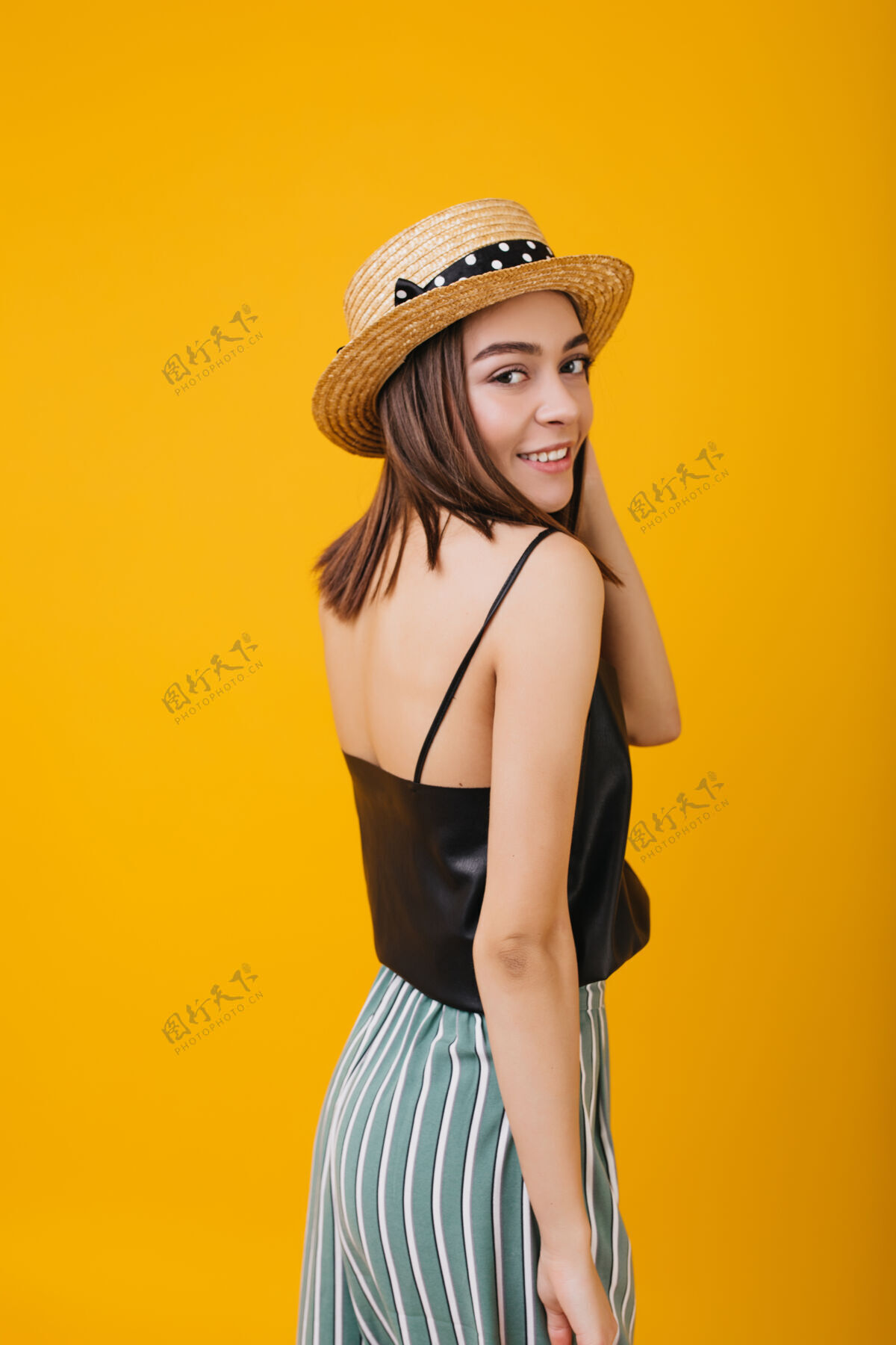 时尚穿条纹裤戴草帽的苗条女孩摆姿势时髦的欧洲女士 黑眼睛孤立配件优雅情感