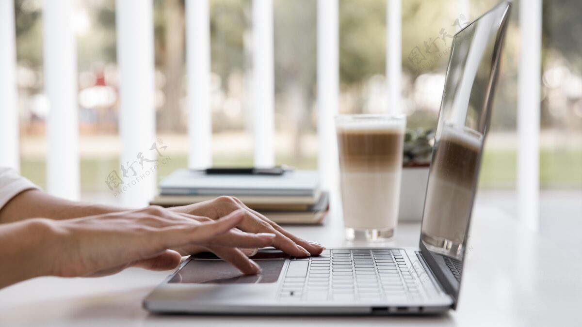 复杂女商人使用笔记本电脑和喝咖啡的侧视图经理笔记本电脑女性