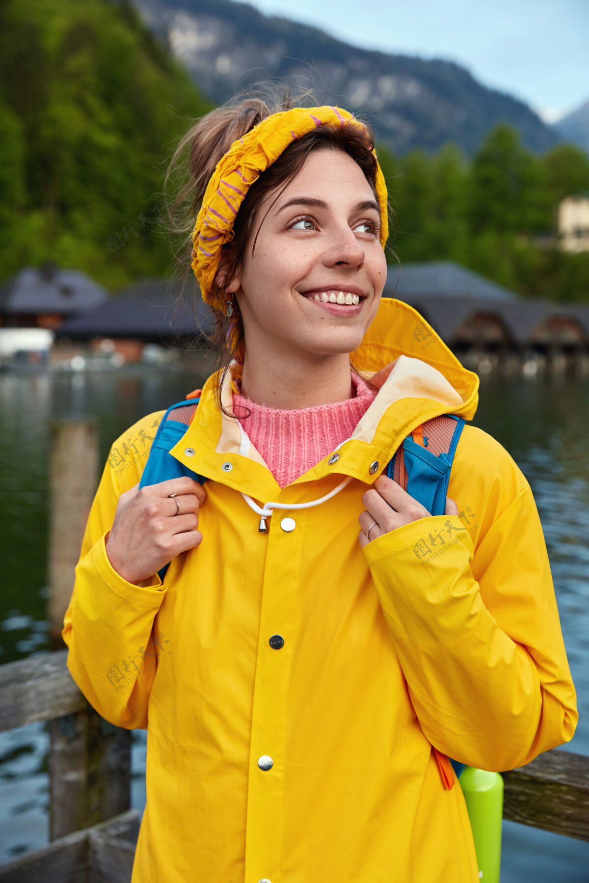 头带开朗的欧洲女游客在山上旅游 在湖边摆姿势 享受阳光和煦的一天刮风女性side