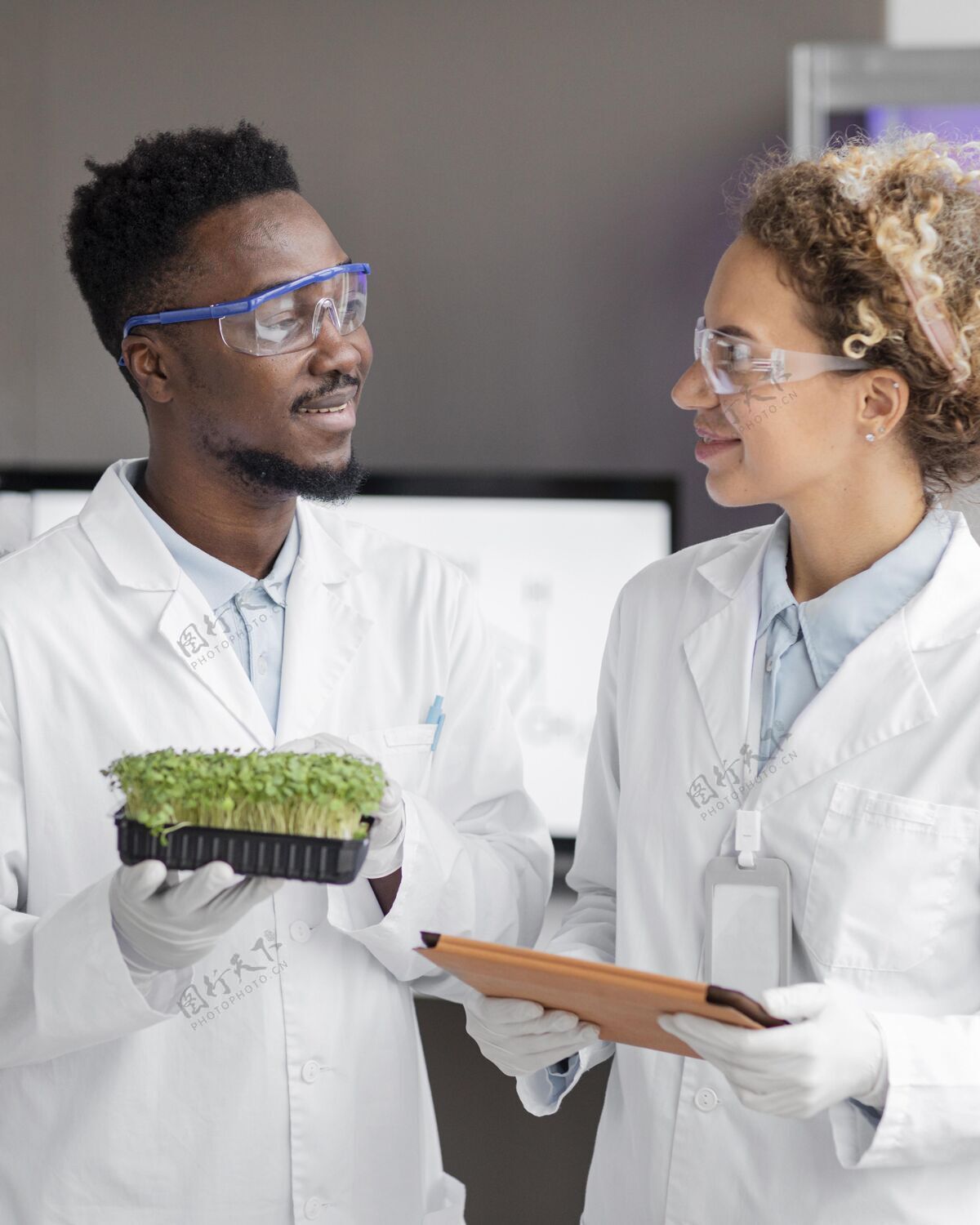 男人微笑的研究人员在实验室里戴着安全眼镜和植物垂直技术安全眼镜