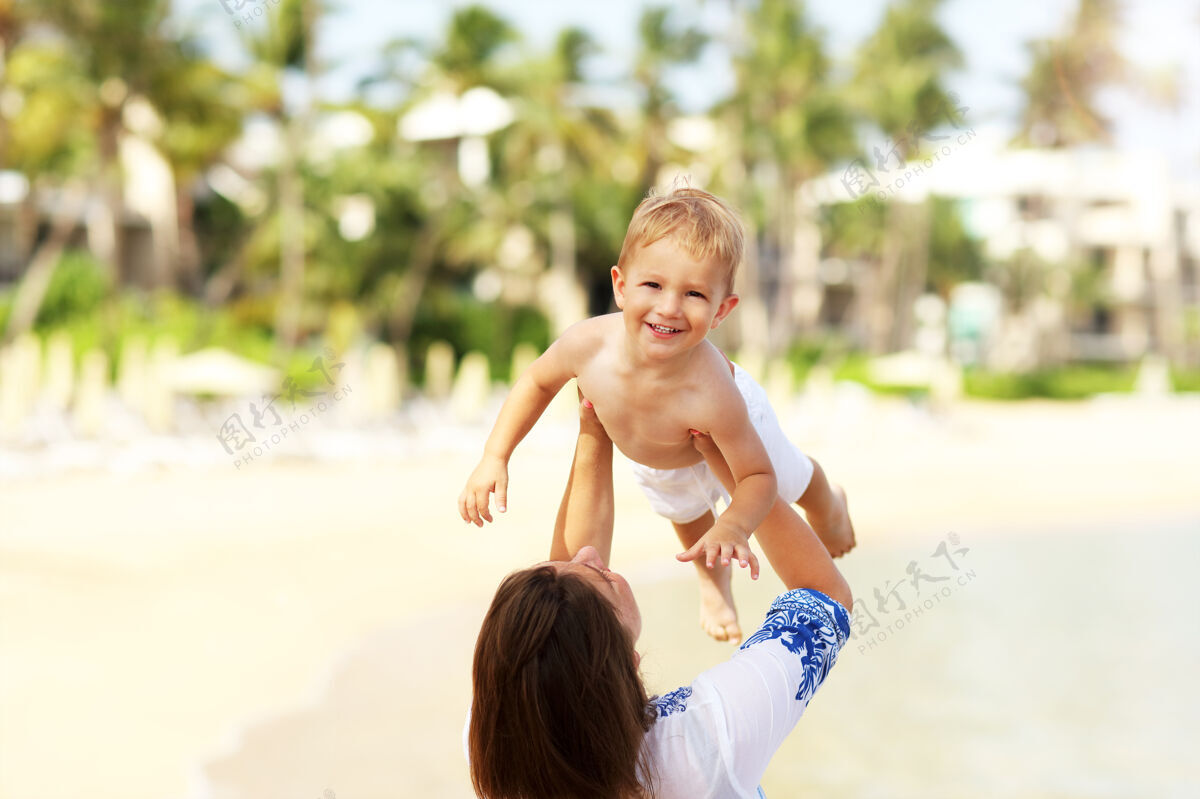 爱妈妈和她的小儿子在沙滩上玩得很开心生活方式夏天快乐